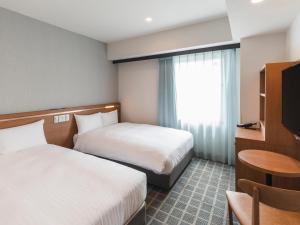 A bed or beds in a room at Sotetsu Fresa Inn Kobe Sannomiya