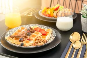 dos platos de gofres y fruta en una mesa con leche en Skaline Luxury rooms Split, en Split