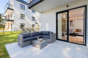 eine Terrasse mit einem blauen Sofa und einem Tisch in der Unterkunft Double Rest in Jastrzębia Góra