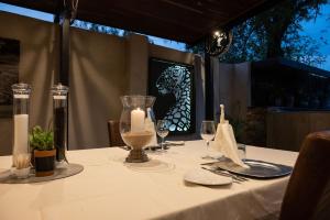 a table with a white table cloth with a candle on it at Chobe River Lodge in Kasane