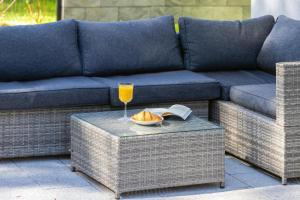 eine blaue Couch mit einem Glas Orangensaft und einem Buch in der Unterkunft Double Rest in Jastrzębia Góra