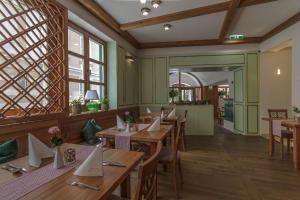 een restaurant met houten tafels, stoelen en ramen bij SPA Hotel Erzherzog Johann in Bad Aussee