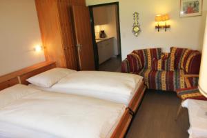 a hotel room with two beds and a chair at Residenza Lagrev 1 Zimmerwohnung Nr 228 - Typ 11A - 2 Etage - Ost in Sils Maria