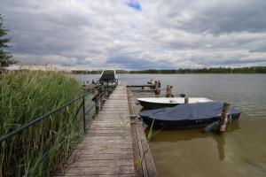 a boat is docked at a dock on a lake at Villa-Pälitzsee in Rheinsberg