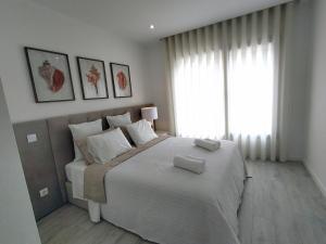 a bedroom with a large bed with two towels on it at Rancho Tá-Mar Apartment Nazaré Beach in Nazaré