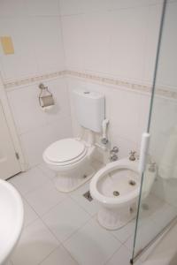 een witte badkamer met een toilet en een wastafel bij El Misti Coliving Obelisco in Buenos Aires