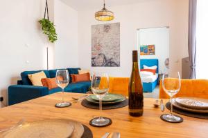 una mesa con copas de vino y una botella en ella en Soulscape Apartments DELUXE Zwickau CityCenter mit TG-Stellplatz und Magenta-TV, en Zwickau