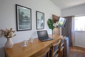 een laptop op een houten bureau in een kamer bij El Misti Coliving Obelisco in Buenos Aires