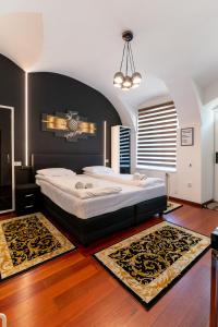 a bedroom with a large bed with a black wall at Demiani House in Sibiu