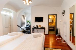 a bedroom with two beds and a television on a wall at Demiani House in Sibiu