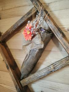 a butterfly on a wooden cross with a flower in it at Le chalet du village in Chambave