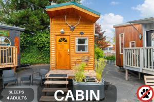 een klein huisje met een houten deur op een patio bij Tiny Digs - Hotel of Tiny Houses in Portland