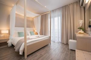 1 dormitorio con cama con dosel y ventana grande en Angelica Hotel, en Limenas