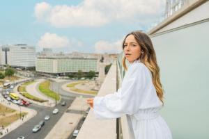 une femme qui regarde par la fenêtre d'un bâtiment dans l'établissement HF Fenix Music, à Lisbonne