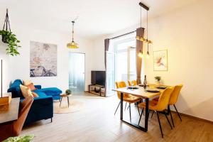 sala de estar con mesa y sofá azul en Soulscape Apartments DELUXE Zwickau CityCenter mit TG-Stellplatz und Magenta-TV, en Zwickau