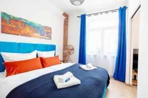 Un dormitorio con una cama azul y blanca con toallas. en Soulscape Apartments DELUXE Zwickau CityCenter mit TG-Stellplatz und Magenta-TV, en Zwickau