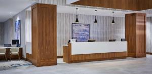 a lobby with a white reception desk and chairs at DoubleTree by Hilton Windsor, ON in Windsor