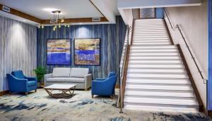 a staircase in a lobby with blue chairs and a couch at DoubleTree by Hilton Windsor, ON in Windsor