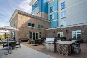 patio ze stołami i krzesłami oraz budynek w obiekcie Homewood Suites By Hilton Myrtle Beach Coastal Grand Mall w mieście Myrtle Beach