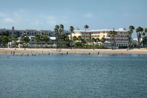 a group of people on a beach near the water at Jamaica Bay Inn Marina Del Rey Tapestry Collection by Hilton in Los Angeles