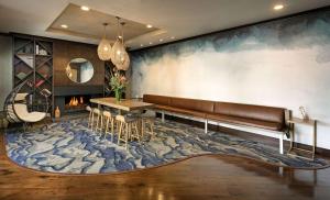 a living room with a bench and a fireplace at Jamaica Bay Inn Marina Del Rey Tapestry Collection by Hilton in Los Angeles