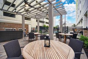 un patio esterno con tavoli, sedie e tende da sole di Home2 Suites by Hilton Houston Medical Center, TX a Houston