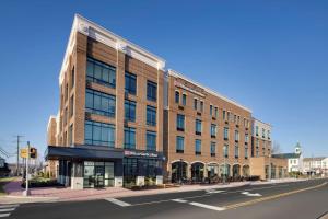 een groot bakstenen gebouw op de hoek van een straat bij Hilton Garden Inn Haymarket in Haymarket