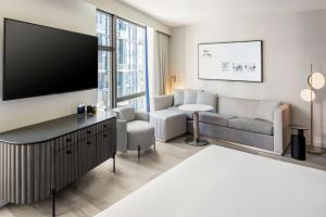 sala de estar con TV de pantalla plana grande en The Morrow Washington Dc, Curio Collection By Hilton, en Washington