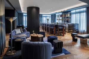 un vestíbulo con un bar con muebles y ools azules en The Morrow Washington Dc, Curio Collection By Hilton, en Washington