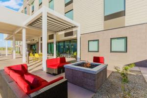 um pátio com cadeiras vermelhas e uma fogueira em Home2 Suites By Hilton North Scottsdale Near Mayo Clinic em Scottsdale