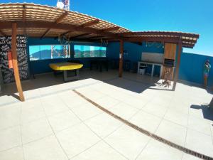 um pátio com uma pérgola de madeira e uma mesa em Pousada Mirante da Prainha em Arraial do Cabo