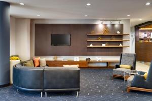 un soggiorno con divano e TV di Courtyard by Marriott Houston NASA Clear Lake a Nassau Bay