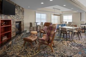 een woonkamer met een open haard en een tafel en stoelen bij Residence Inn Manassas Battlefield Park in Manassas