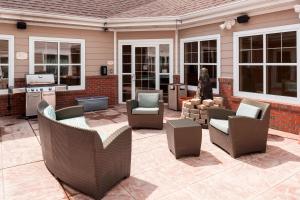 een patio met stoelen en tafels en een keuken bij Residence Inn Manassas Battlefield Park in Manassas