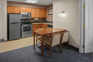 een keuken met een houten tafel en apparatuur bij Residence Inn Manassas Battlefield Park in Manassas