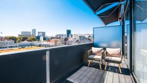 a balcony with two chairs and a view of a city at Hills Hotel Lisboa in Lisbon