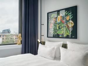 una camera da letto con un letto con lenzuola bianche e una finestra di URBAN LOFT Berlin a Berlino