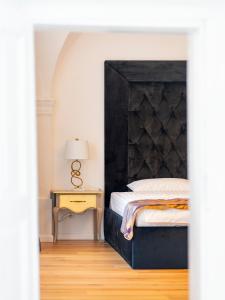 1 dormitorio con 1 cama con cabecero negro y mesa en Sia Boutique Aparthotel, en Sibiu