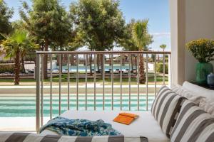 ein Wohnzimmer mit einem Sofa und Poolblick in der Unterkunft Anantara Vilamoura Family Friendly in Vilamoura