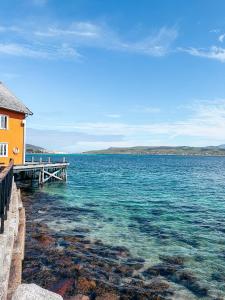 ein großer Wasserkörper mit einem Haus und einem Dock in der Unterkunft Sandtorgholmen Hotel - Best Western Signature Collection in Harstad