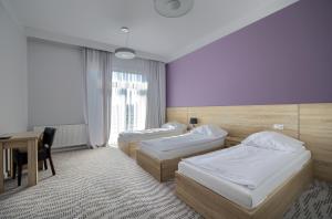 a hotel room with two beds and a desk at Nova Stodola in Kłomnice