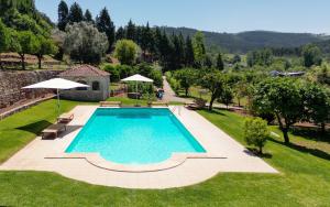 uma imagem de uma piscina num jardim em Quinta do Calvário 