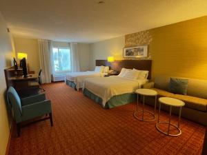 a hotel room with two beds and a couch at Fairfield Inn and Suites by Marriott Potomac Mills Woodbridge in Woodbridge