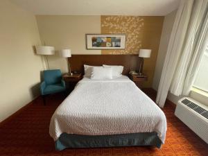 a hotel room with a bed and a blue chair at Fairfield Inn and Suites by Marriott Potomac Mills Woodbridge in Woodbridge