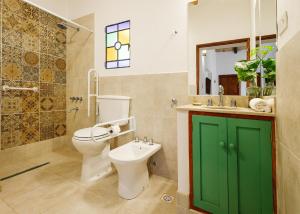 a bathroom with a toilet and a green door at Nido de cóndores in Purmamarca