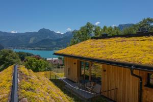 a house with a grass roof with a view of a lake at Balthasar Volcano Apartments - Adults only in St. Wolfgang