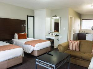 een hotelkamer met 2 bedden en een bank bij Mercure Hotel Nelspruit in Nelspruit