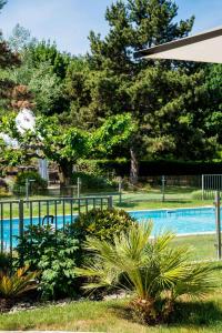 une piscine avec une clôture et quelques plantes dans l'établissement Best Western Plus Clos Syrah, à Valence