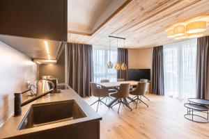 a kitchen and dining room with a table and chairs at Zillertal Suites Fügen by ALPS RESORTS in Fügen