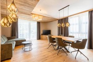 a living room with a dining room table and chairs at Zillertal Suites Fügen by ALPS RESORTS in Fügen